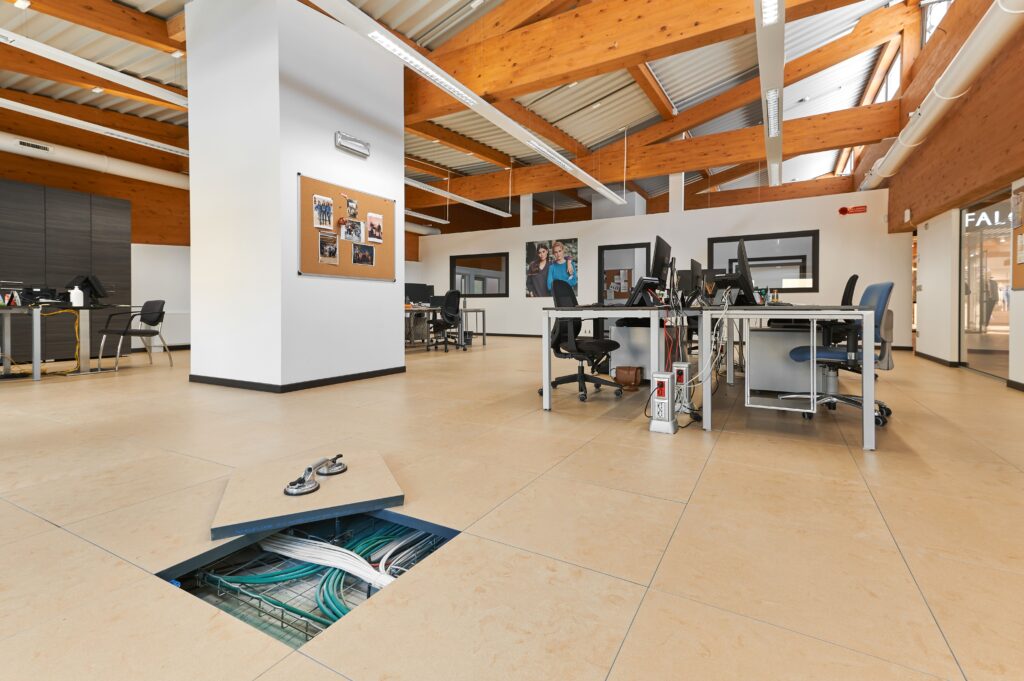 ufficio con scrivanie e dettaglio pavimento sopraelevato