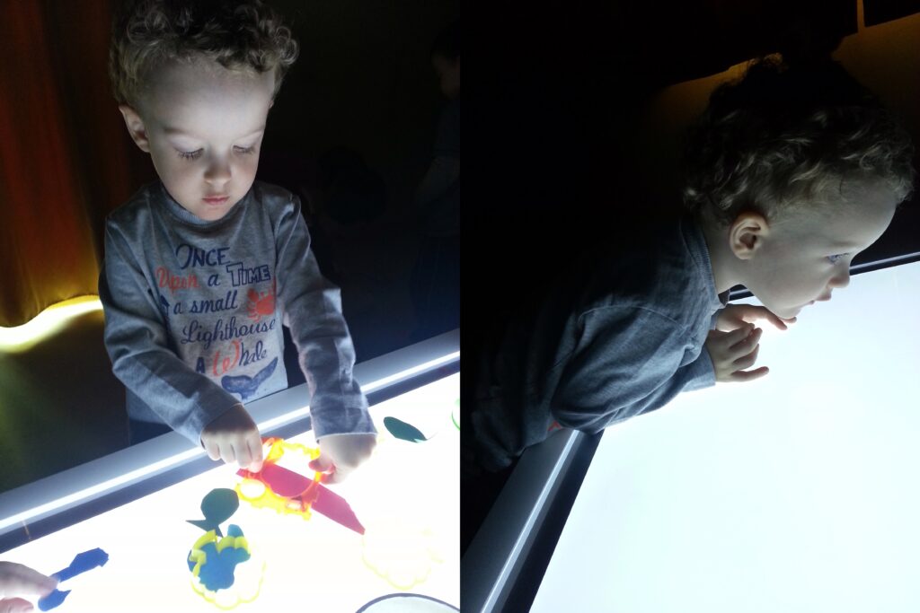 bambino che gioca con lavagna luminosa